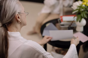 Adult daughter reviewing financial documents with her elderly mother at a kitchen table