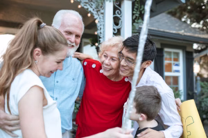 A multigenerational family gathered on the front porch of their home